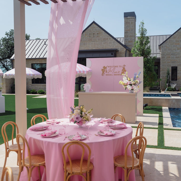 Pastel butterfly themed balloon arch in mint, lilac and blush built around a white arched backdrop in a panelled room.